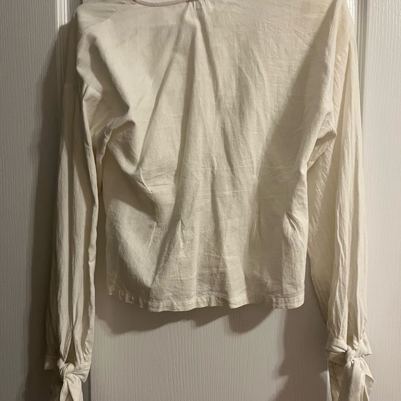 Fitted white button up shirt with tie-able strings on the ends of the sleeves. - Picture 2 of 3